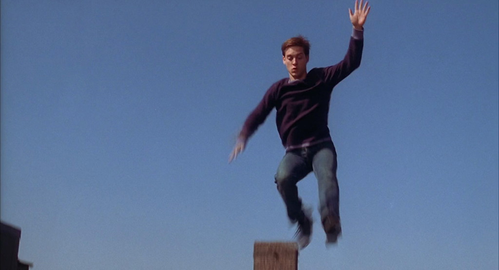 Peter Parker (Tobey Maguire) leaps across rooftops with neither style nor grace.
